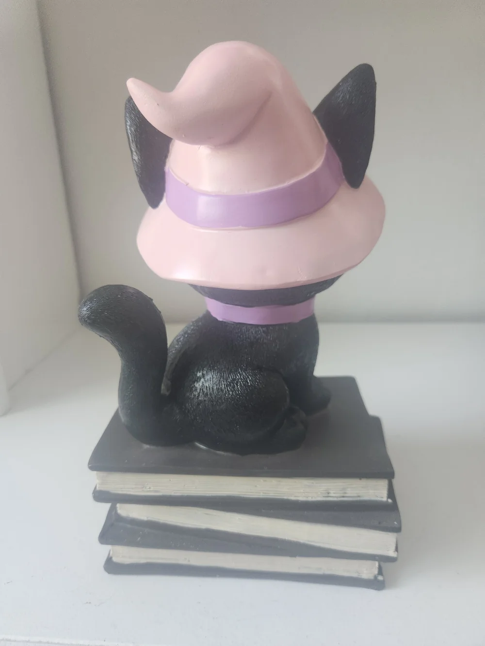 Black Cat Wearing Pink Witches Hat Sitting On Top Of Books Figuring